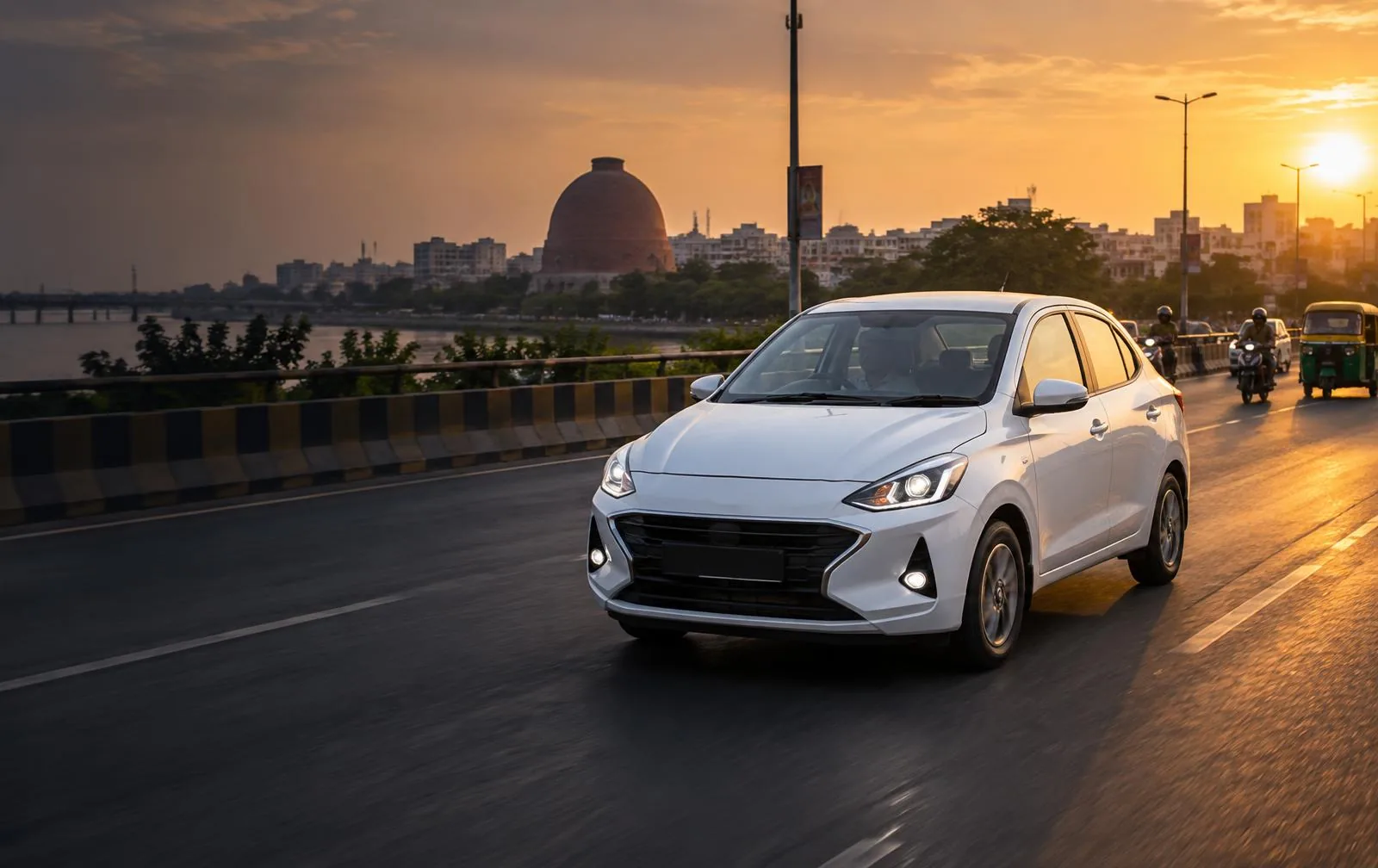 White Nice Rides sedan driving along Patna's riverfront at golden hour